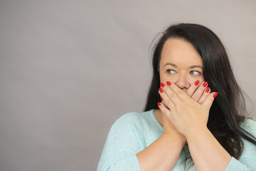Ashamed woman covering her mouth with hands