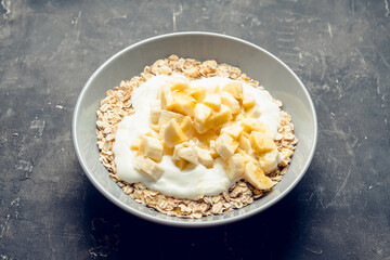 Healthy and tasty breakfast with muesli, yogurt, bananas and honey. Selective focus. 