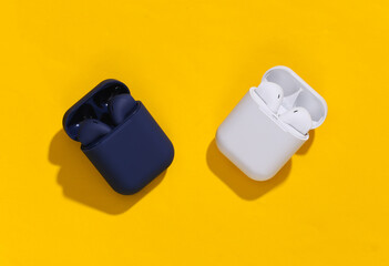 Two charging case with true wireless bluetooth headphones or earbuds on bright yellow background....