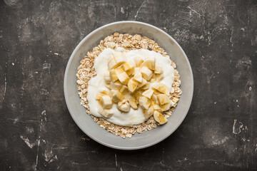 Healthy and tasty breakfast with muesli, yogurt, bananas and honey. Selective focus. 