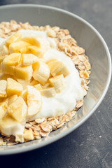 Healthy and tasty breakfast with muesli, yogurt, bananas and honey. Selective focus. 