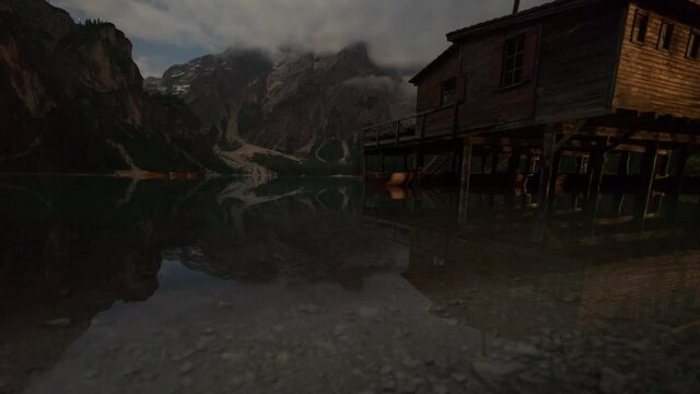 Beautiful Pragser Wildsee Lake at Dolomits in Italy with Hut on the Left and complete Sunriese, Clouds moving like pumping