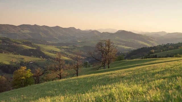 Landscape at Spring Time with far away Mountains and Green gras in the Front, moving Timelapse