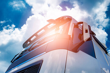 Front side semi truck with a blue sky and cloudy. Road freight transportation.
