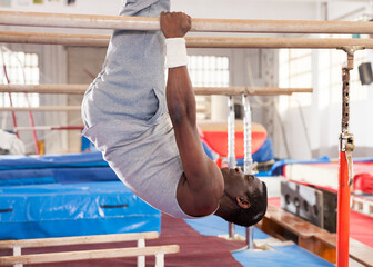Portrait of adult african man training on gymnastic equipment in gym
