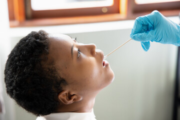 African woman getting throat swab test; concept of universal COVID-19 testing, contact tracing,...