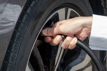 Inflate the tire. Pumping air into auto wheel.