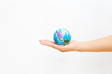 World map foam Earth Globe stress relief bouncy ball in girl hand on white background, world environmental