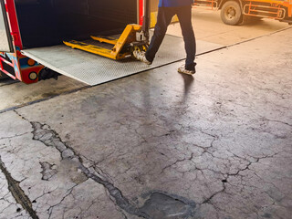 Worker driving forklift loading and unloading shipment carton boxes and goods on wooden pallet from container truck to warehouse cargo storage in logistics and transportation industrial 