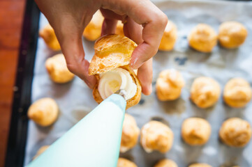 squeeze whipping cream into cream puffs