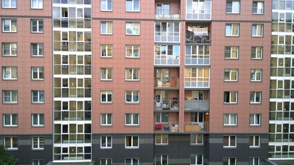 Facade of a new multi-story residential building. Sale and rental of economy class apartments and comfortable housing. Cityscape. Windows and balconies. City living. Real estate. Mortgage concept.