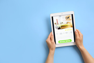 Hands with tablet computer on color background. Concept of online booking