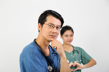 Young Asian male female doctor wearing apron uniform tunic stethoscope look at camera hart hand sing