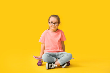 Fototapeta na wymiar Cute little girl with skateboard on color background