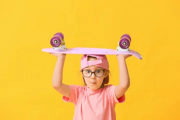 Schilderijen op glas Cute little girl with skateboard on color background © Pixel-Shot