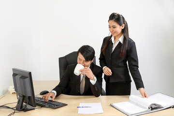 Young Asian male female wearing suit sitting at office desk coffee cup see discuss computer document