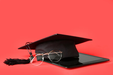 Graduation hat, tablet computer and glasses on color background