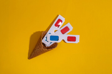 Ice cream waffle cone with 3d glasses on yellow bright background with deep shadow, top view. Flat lay 80s
