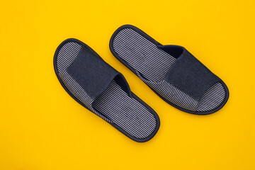 Men's sleeping room slippers on a yellow background. Top view