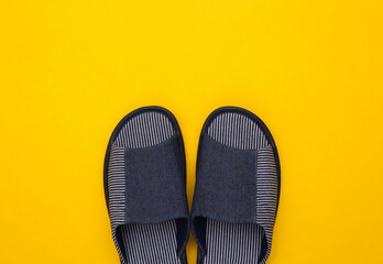 Men's sleeping room slippers on a yellow background. Top view