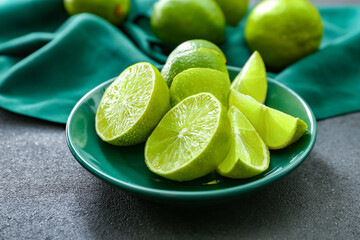 Plate with fresh cut limes on table
