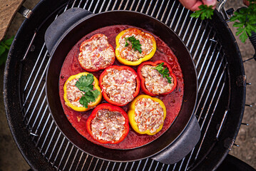 chef making stuffed pepper with tomato sauce