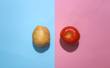 Potato and tomato on blue pink pastel background. Minimalism food flat lay. Top view