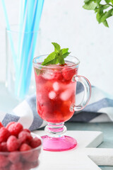 Cup of cold raspberry tea on table