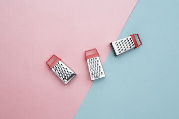 Mini graters on pink blue background. Top view