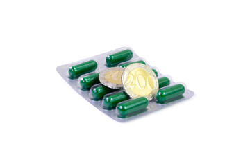 Package of green pills with two kazakhstani coins isolated on white background. Healthcare, pharmacy business and medicine price growth concept