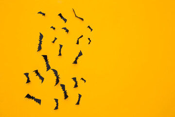 Flying bats on yellow background. Halloween background. Copy space. Top view. Flat lay