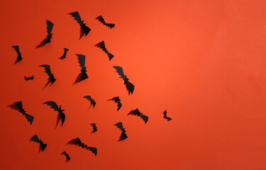 Paper cut Flying bats and on orange bright background. Halloween background. Top view.  Copy space