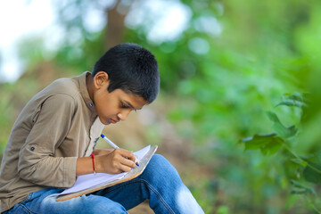 Indian child writing on note book