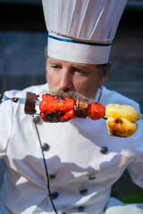 Chef with barbecue of vegetables cooked on the grill. Outdoor barbecue