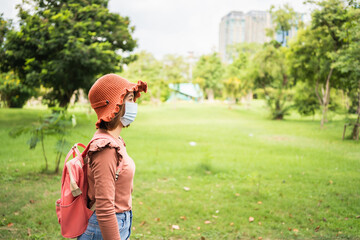 young women wearing face mask protection as prevention for coronavirus and walking in park