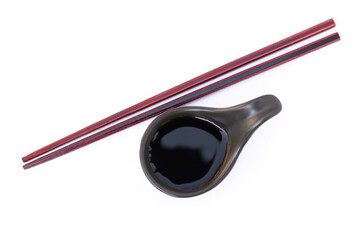 soy sauce in small bowl and chopsticks isolated on white background. 