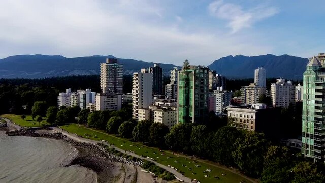 Aerial flyover English Bay to Stanley Park Posh VIP Condo Towers by the beach Mountain valley party place no so crowded for the summer of 2020 green park swimming beach suntainning walking jogging