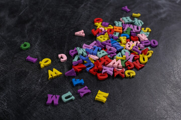 Lots of colored letters on a chalk board background. Back to school. Top view.