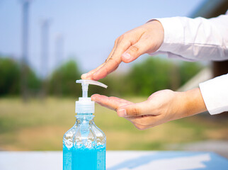 Asian office men clean their hands with alcohol-based hand washing spray as a hygiene measure to...