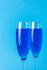 Two wineglasses close up of blue champagne on a blue background. Shallow depth of the field, copy space for you text