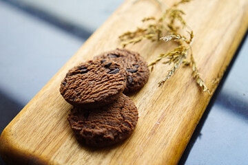 chocolate cookies and dark chocolate grain on wooden board background