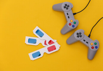 Obraz premium Retro gamepads, 3d glasses on yellow background. Retro gaming. Stereo Video game, 80s. Top view. Flat lay