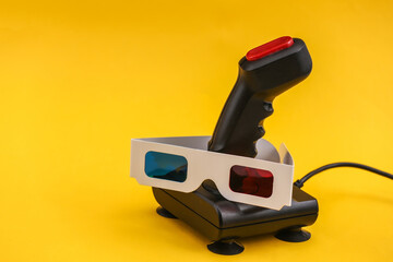 Retro joystick with 3d glasses on a yellow background. Attributes 80s