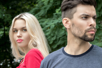 Fototapeta premium A handsome man with stubble on his face turned away from his girlfriend, leaving to the side, a blonde girl with red lipstick looks at him, expecting him to return