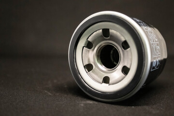 Black car oil filter on black background