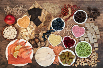 Health food for vitality & fitness with foods high in vitamins, minerals, anthocyanins, antioxidants, smart carbs, protein & omega 3. Flat lay on bamboo mat and rustic wood. 