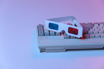 Old pc keyboard with 3d glasses in pink blue gradient neon, holographic light. Retro Attributes 80s