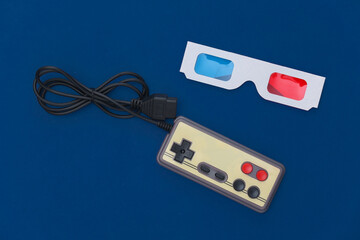 Wired retro gamepad and anaglyph 3D glasses on a classic blue background. Retro Attributes, 80s. Top view