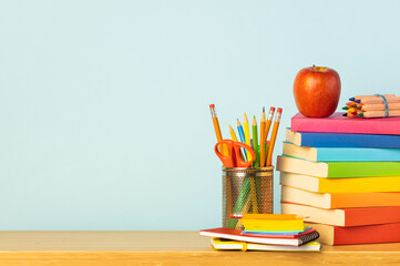 Books and pencil holder on school desk