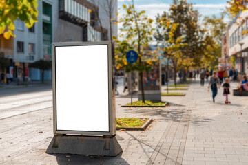 Blank white billboard in the city street with people walking in the background - 369642147